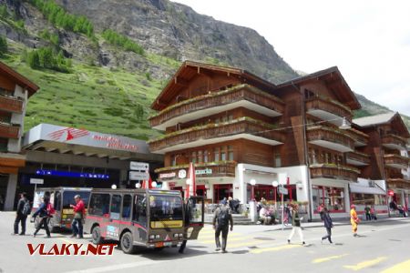 Zermatt, vstup na nádraží a před ním elektrické taxíky