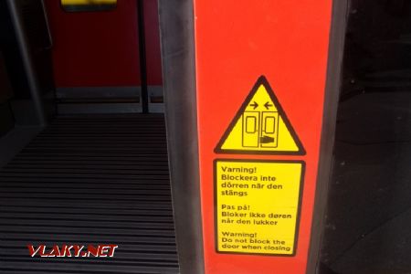 Trojjazyčný varovný nápis na dveřích elektrické jednotky řady X31: nahoře švédština, dole dánština, 16.04.2021 © Jan Přikryl