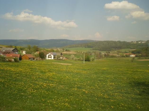 Krajina z okna vlaku mezi Waldmünchenem a Chamem- v pozadí hraniční hřeben s rozhlednou na Čerchově. 24.4.2011 © Jan Přikryl
