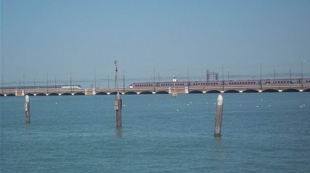 Benátky: na mostě přes lagunu zleva přijíždí souprava "vysokorychlostního" vlaku kategorie Frecciabiance, vpravo jednotka řady ETR 600. 17.8.2012 © Jan Přikryl